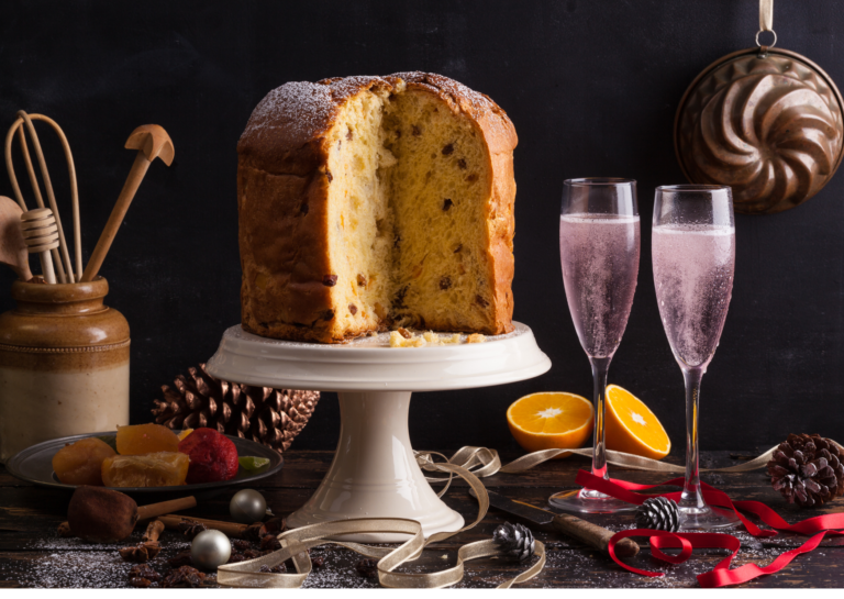 foto di un panettone su una tavola imbandita e 2 bicchieri di spumante sul retro